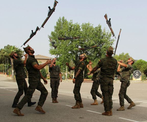 Legionarios lanzando sus fusiles al aire durante un desfile, tradición característica de La Legión