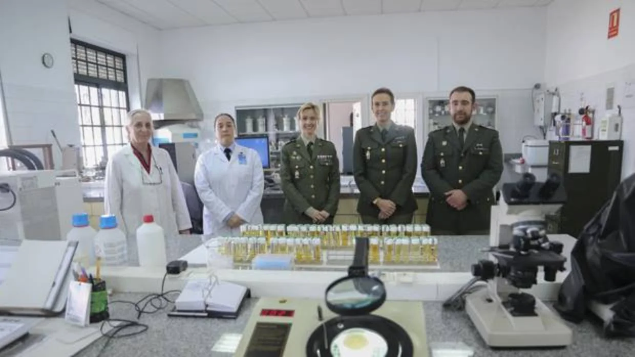 Personal militar y civil del laboratorio de farmacia militar, con muestras y microscopios