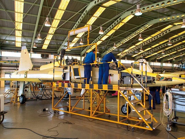 Técnicos trabajando en el mantenimiento de un avión dentro de un hangar de la Maestranza Aérea