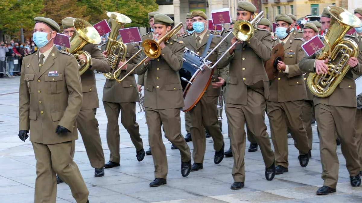 Banda militar desfilando con instrumentos de viento y percusión